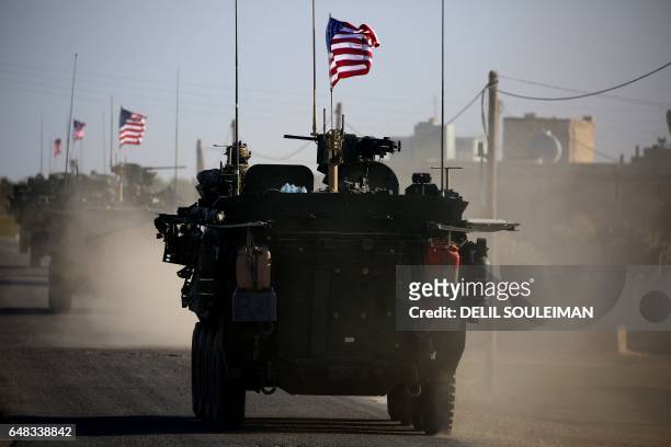 Convoy of US forces armoured vehicles drives near the village of Yalanli, on the western outskirts of the northern Syrian city of Manbij, on March 5,...
