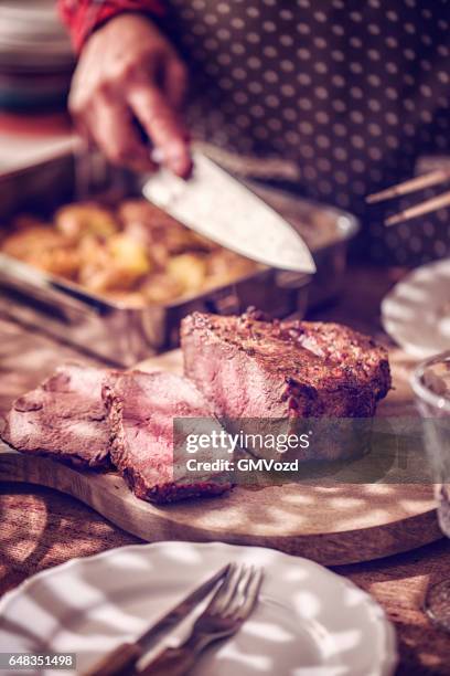 eating roast beef with potatoes and root vegetables - roast beef dinner stock pictures, royalty-free photos & images