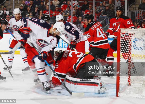 Nick Foligno of the Columbus Blue Jackets is stopped by Cory Schneider of the New Jersey Devils during the first period at the Prudential Center on...
