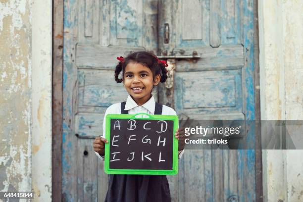 little school girl holding slate - village stock pictures, royalty-free photos & images