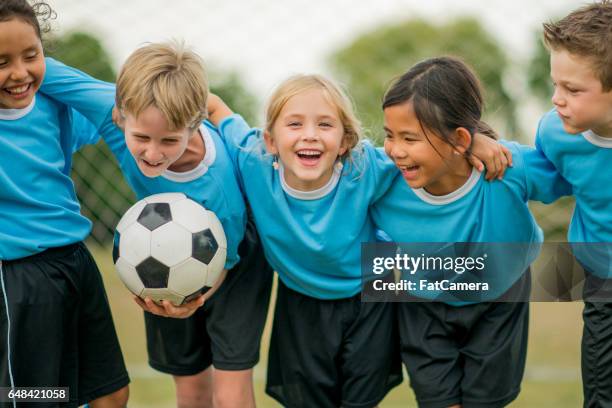 vrienden op een voetbalteam - children football stockfoto's en -beelden