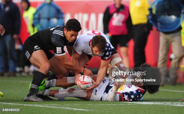 United States players Stephen Tomasin, center and United States player Folau Niua fight New Zealand player Dylan Collier for the ball during their...