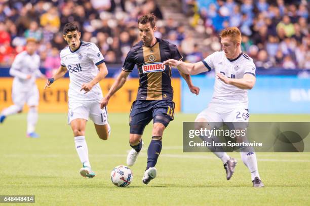 Philadelphia Union forward Chris Pontius kicks the ball ahead of defender Tim Parker and Vancouver Whitecaps midfielder Matias Laba during the game...