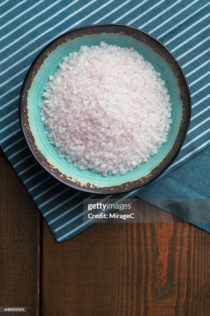 Bowl Filled With Mineral Salt On Wooden Surface