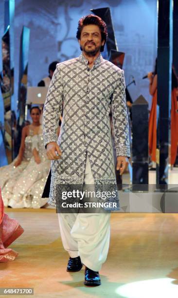 Indian Bollywood actor Shah Rukh Khan showcases a creation by designer Manish Malhotra at the fundraiser Mijwan 2017 fashion show in Mumbai on March...