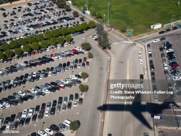 shadow of an aiplane on a parking lot - parking log stock pictures, royalty-free photos & images