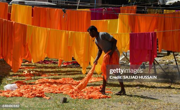 An Indian laundry worker hangs freshly washed sheets to dry in the early morning at an open-air laundry facility or "dhobi ghat" in New Delhi on...