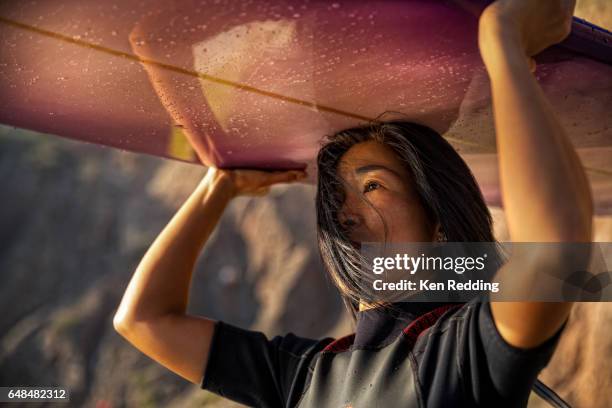 asian woman with surfboard - californie surf stockfoto's en -beelden