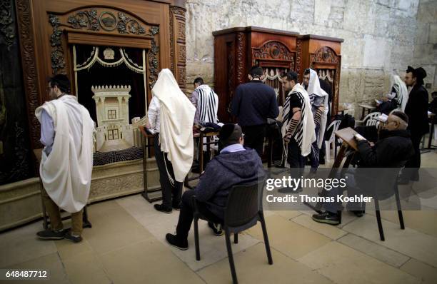Jerusalem, Israel Jews are praying in a hallway next to the Wailing Wall in the historic city center of Jerusalem. The wooden shrines serve to store...