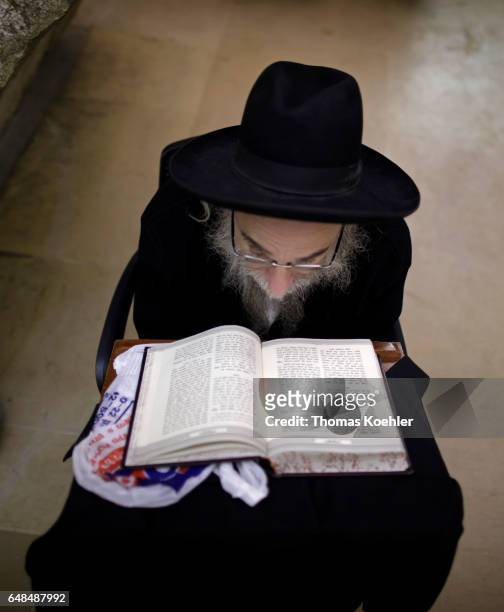 Jerusalem, Israel A Jewish man reads in the Holy Scripture Tanach in a hallway next to the Wailing Wall in the historic city center of Jerusalem on...