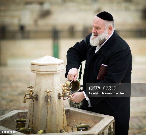 Jerusalem, Israel A Jewish man is washing his hands before the prayer at the Wailing Wall in the historic city center of Jerusalem on February 08,...