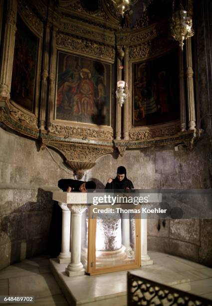 Jerusalem, Israel Two Christian women stand at an altar in the Church of the Holy Sepulchre. Historic city center of Jerusalem on February 08, 2017...