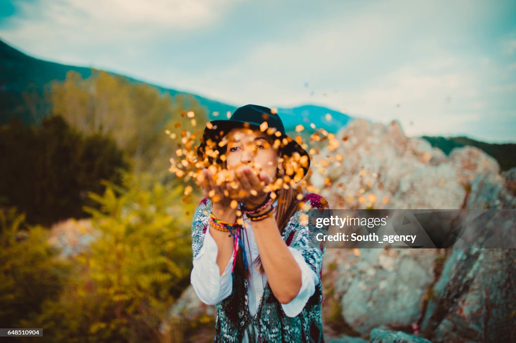 Hippie girl blowing confetti