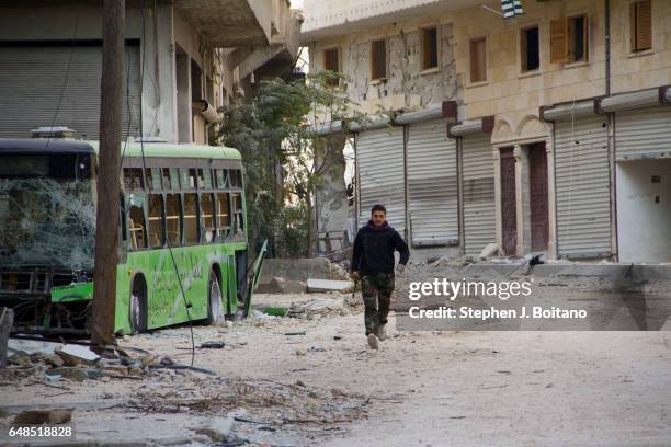 Free Syrian Army Soldier runs past a sniper alley in Aleppo.