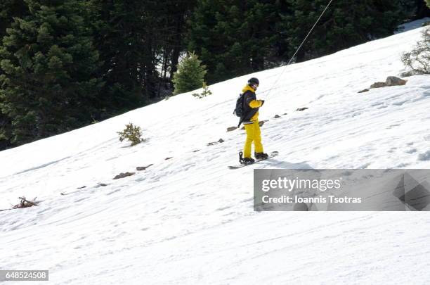 snowboarder in drag lift going uphill - alpine skiing lift stock pictures, royalty-free photos & images