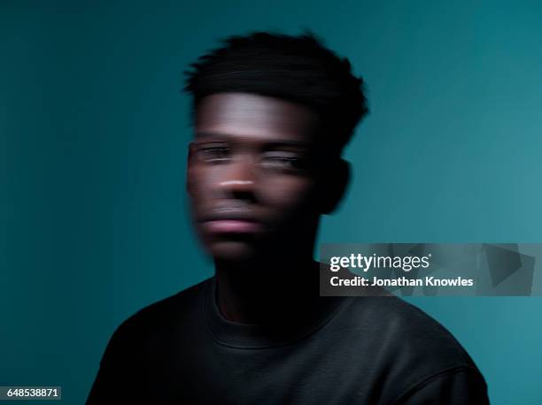 blurred motion portrait, dark skinned male - handsome man serious tshirt stock-fotos und bilder