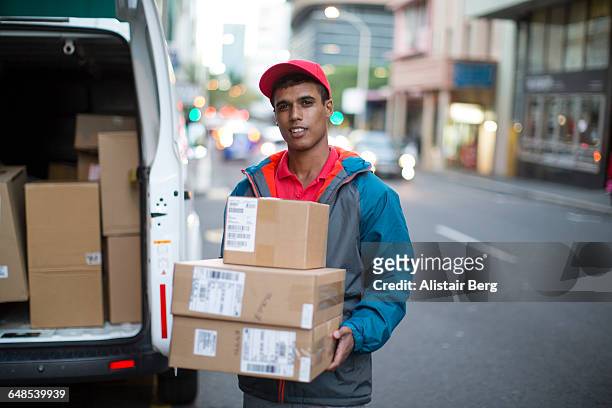 courier delivering parcels and boxes - delivery person fotografías e imágenes de stock