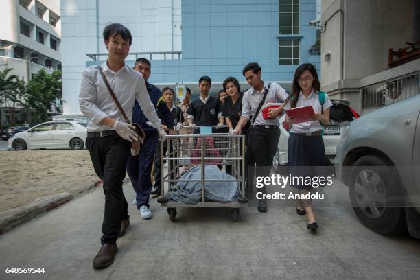 Veterinarian Nantarika Chansue and her team from the Veterinary Hospital of Chulalongkorn carry the Sea Turtle named 'bank' from the surgery building...