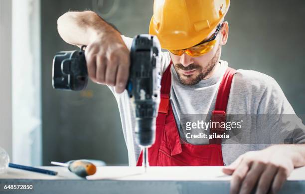 construction worker assembling a drywall. - electric screwdriver stock pictures, royalty-free photos & images