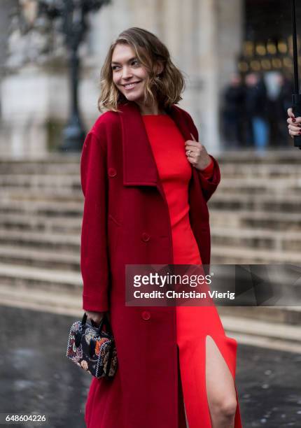 Arizona Muse wearing a red dress and wool coat outside Stella McCartney on March 6, 2017 in Paris, France.