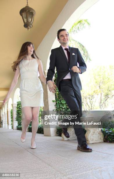 enthusiastic couple running together on sidewalk - skip stockfoto's en -beelden