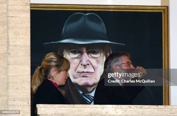 Sinn Fein president Gerry Adams and northern leader Michelle O'Neill walk past a portrait of the late Ian Paisley as he arrives for a press call at...