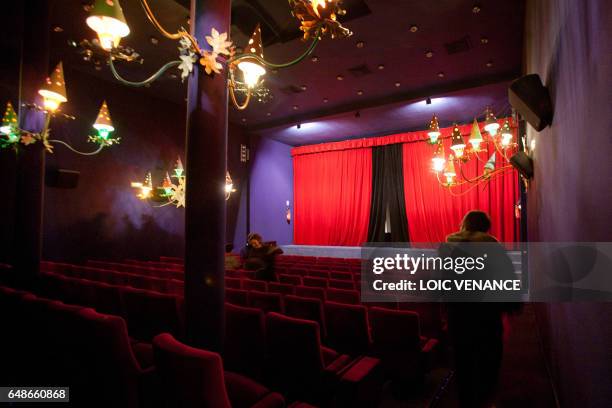 People arrive to watch a movie at the Studio 28 cinema theater on January 12, 2011 in Paris. Lights were designed by French artist Jean Cocteau. AFP...