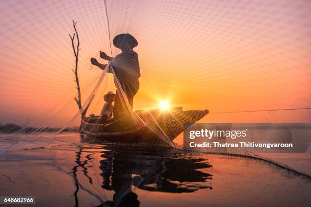 silhouette fisherman at sunrise of bangpra lake in action when fishing, thailand - myanmar food stock pictures, royalty-free photos & images