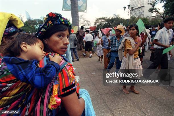 Guatemalan woman watches a procession of Mayan communities in front of the National Palace in Guatemala City, who came to watch the peace-signing...