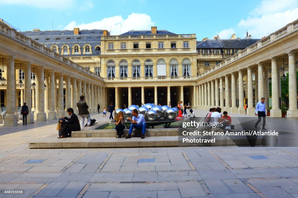 Palais Royal, Cour (courtyard) d’Honneur, people near the Sphérades or Fontaines (fountains) de Pol Bury