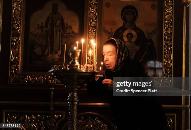 Woman lights a prayer candle at an Orthodox church on March 6, 2017 in Moscow, Russia. Relations between the United States and Russia are at their...