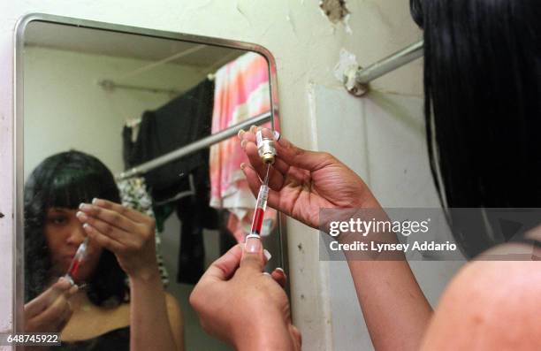 Kima prepares a shot containing Delestrogen and Vitamin B12 in her bathroom in Harlem, New York City on Dec. 1, 1999. Kima and Charisse buy the...