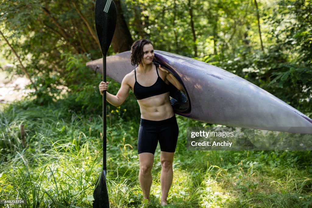 Female kayaker victory posing with her kayak