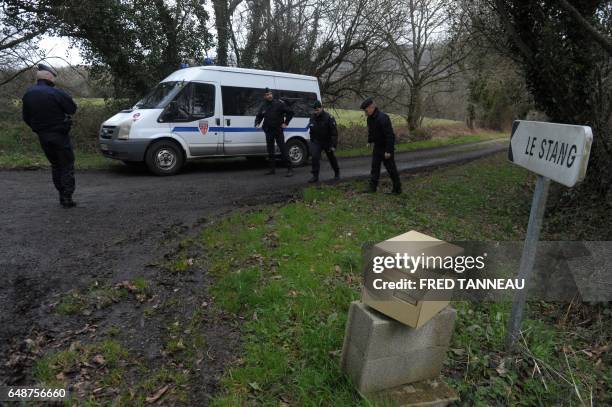 French CRS police officers stand as they investigate near the house of Lydie Troadec, sister of Pascal Troadec who went missing with his wife and two...