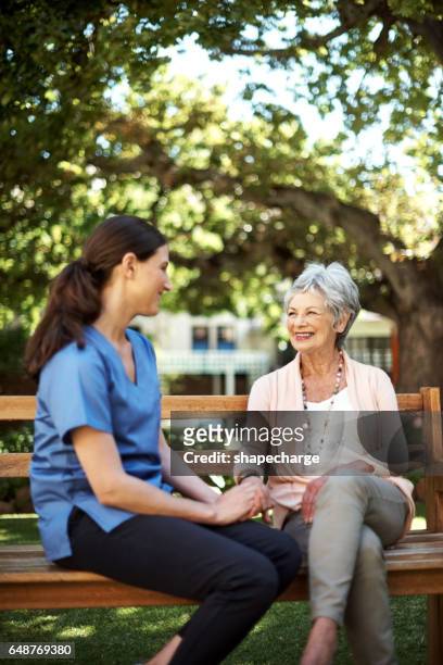 casual conversation out in the garden - young woman and senior lady in a park stock pictures, royalty-free photos & images