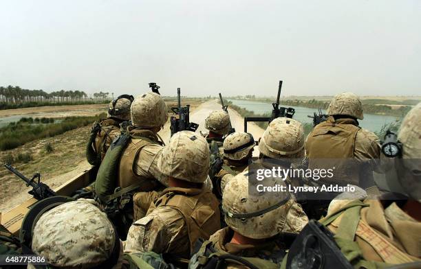 Squad of U.S. Marines rides a 7-ton truck after being ambuhed several times by insurgents while on a 'movement-to-contact mission in order to flush...