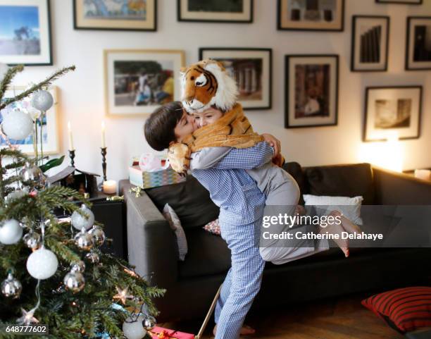 a brother and a sister unwrapping their christmas presents - kids christmas lifestyle imagens e fotografias de stock