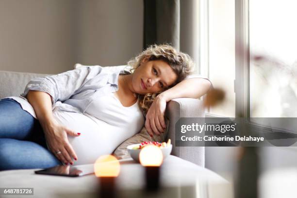 a pregnant woman at home - cheveux blonds stockfoto's en -beelden
