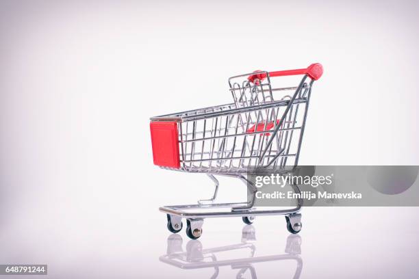 shopping cart on white background - shopping trolleys stockfoto's en -beelden