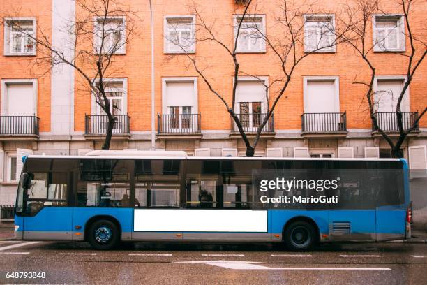 blauer bus auf der straße - seitenansicht stock-fotos und bilder