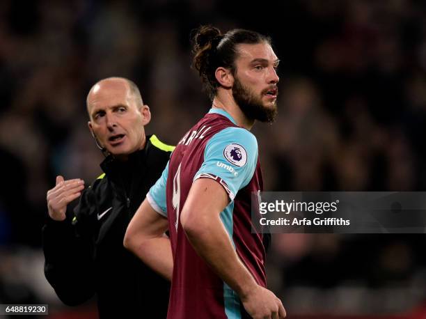 Andy Carroll of West Ham United with fourth official Mike Dean during the Premier League match between West Ham United and Chelsea at London Stadium...