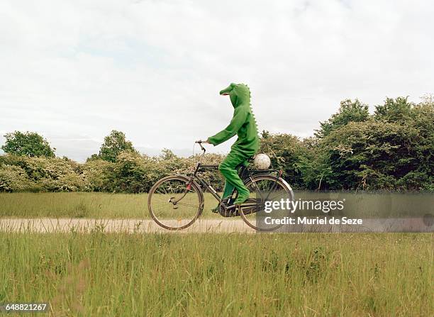 crocodile on bicycle - maskerade stock-fotos und bilder