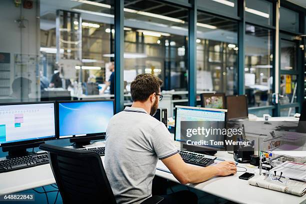 engineer in control room of a factory - news foto e immagini stock