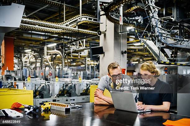 engineers working on laptop in a large printer - man and machine stock-fotos und bilder