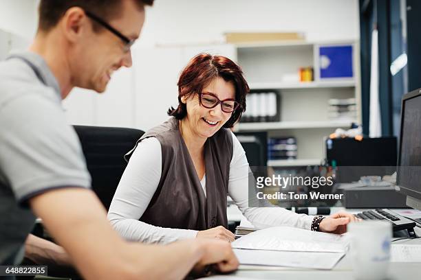 female manager with a worker in her office - frau aktenordner stock-fotos und bilder