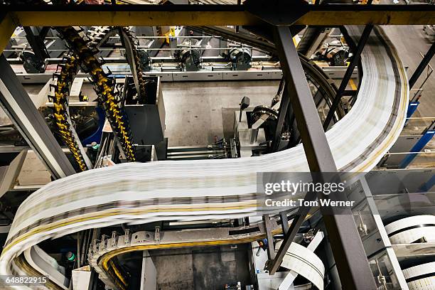 conveyor belt with newspapers in a printery - printing industry stock pictures, royalty-free photos & images