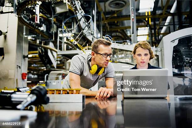 engineers working on laptop in a large printer - team industrie stockfoto's en -beelden