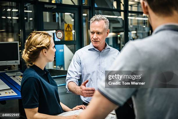 manager and trainee talking during a meeting - persone fabbrica foto e immagini stock