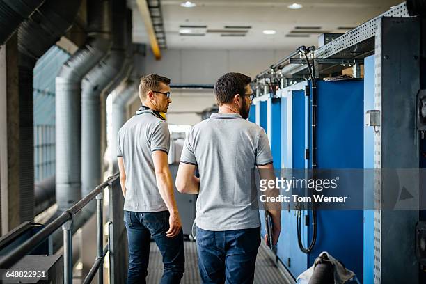 two engineers inspecting machines - gray polo shirt stock pictures, royalty-free photos & images