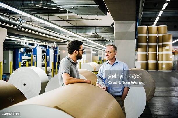 manager and worker in a paper roll warehouse - paper industry stock-fotos und bilder